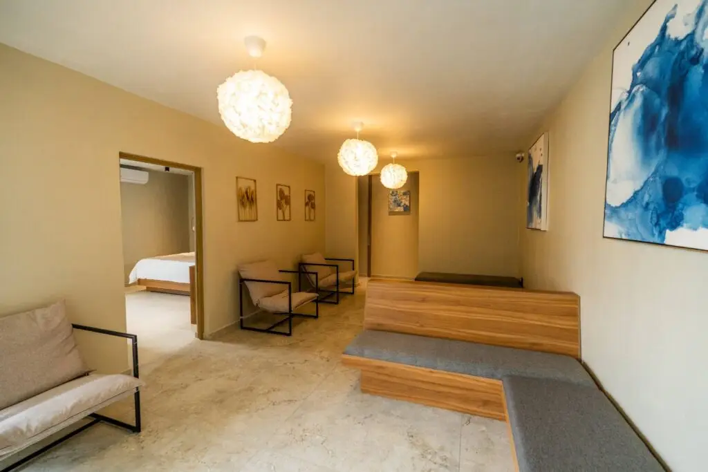 Área común del Hotel Casa Mía con diseño moderno, mobiliario cómodo e iluminación cálida.
