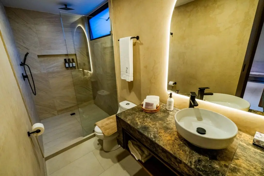 Espejo con luz LED y lavabo moderno en el baño de una suite del Hotel Casa Mía en Zamora
